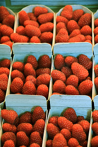 市场摊位上小盒子里的草莓