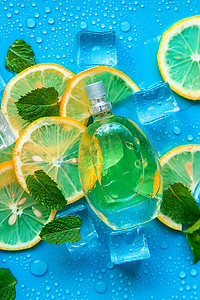 dior花漾香水摄影照片_蓝色背景上的香水，配有冰块和薄荷柠檬。
