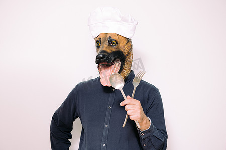 戴着狗面具的厨师展示餐具