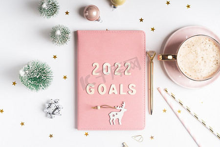 顶部视图桌面圣诞粉色记事本，带有 2021goals 字母文本。