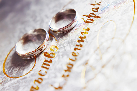 一对金色结婚戒指背景上带有金色字母组合。