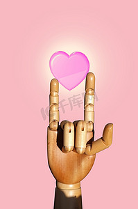 一只手势摄影照片_一只木娃娃的手在粉红色背景上做爱的标志，概念情人节