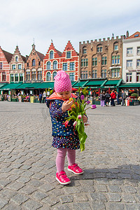 比利时布鲁日 — 2022 年 4 月 23 日，一个拿着一束郁金香的孩子。