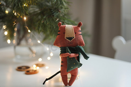 2022虎年背景摄影照片_可爱的毛绒玩具老虎，在舒适的圣诞节或新年背景上装饰。 