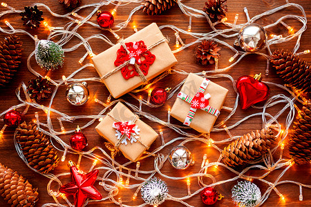 圣诞节和新年背景与圣诞装饰-球、星星、银色闪闪发光的雪花、心和灯泡在木桌上。