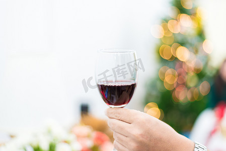 一杯红酒，用于在圣诞树背景的派对上敬酒。
