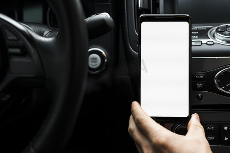 特写手持智能手机显示白色空白屏幕汽车