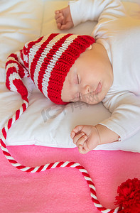 婴儿戴着圣诞帽睡觉。
