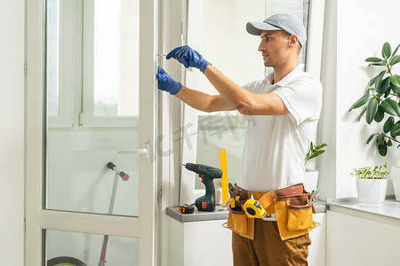 修理工在公寓内修理、调整或安装金属塑料窗户。