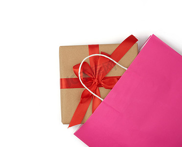 白色背景上带礼品盒的粉色纸袋