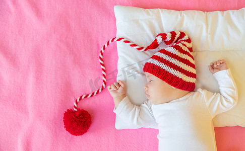 婴儿戴着圣诞帽睡觉。