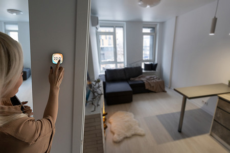 墙上的恒温器智能家居家庭自动化控制面板，用于冬季房屋温度横幅全景。