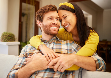 客厅沙发上的多样性、爱和幸福的情侣在一起，在家里分享亲密的时刻。