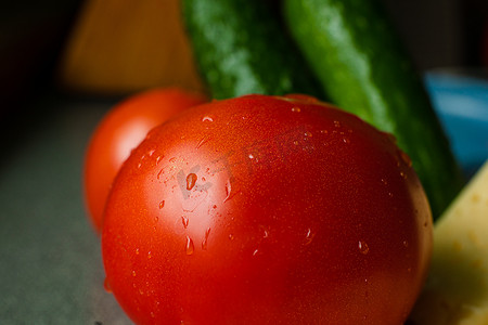 桌子上放着一个洗过的纯红番茄，上面有水滴