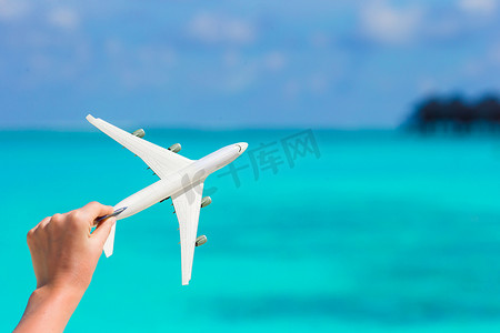 绿松石海背景下一架飞机的白色小缩影