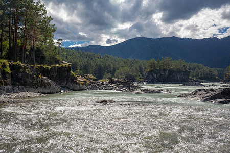 瀑布水流摄影照片_一条水流湍急、宽阔饱满的山区河流。