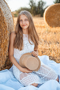 农田里穿白裙、戴草帽的小女孩