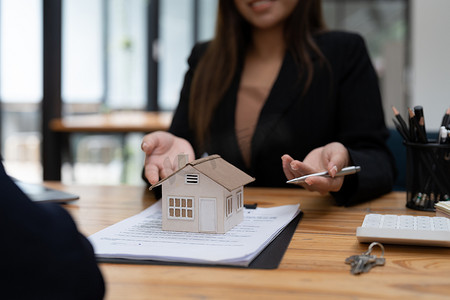 房地产经纪人或银行职员通过购房合同或办公室贷款和利率向客户描述贷款利息。