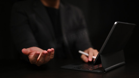 使用电脑平板电脑和手展示或拿着东西的商人的裁剪图像。