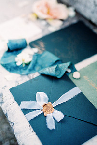 瓷砖上铺着海军蓝色婚礼信封，上面有丝带和蜡封