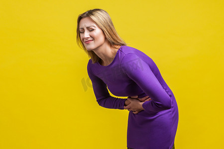 胃胀摄影照片_黄色背景上的情感美丽的女人。