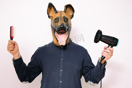 戴狗面具的男人展示发刷和吹风机