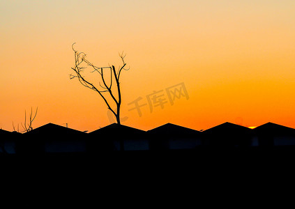 日落真实摄影照片_城市山墙屋顶房屋人物轮廓在日落橙色的天空