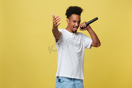 男歌手摄影照片_年轻英俊的非洲裔美国男歌手用麦克风表演。