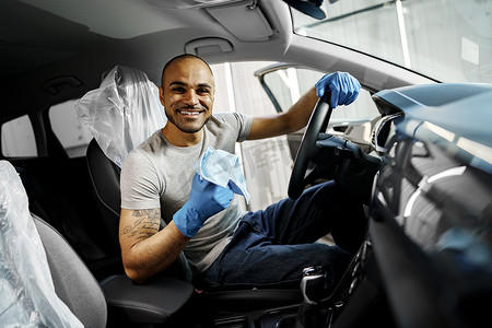 清洁汽车内饰的男子，洗车服务中的汽车细节