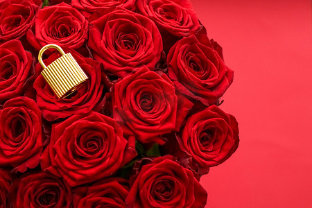 玫瑰金背景摄影照片_情人节卡片的爱锁、金挂锁和红色背景的豪华玫瑰花束