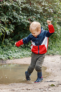 年幼的孩子们在泥泞的水坑里玩耍