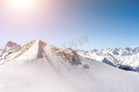 俄罗斯高加索地区冬季雪山全景，背景明亮的阳光