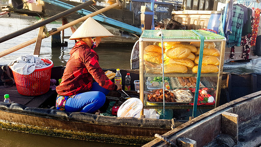 街头食品摊贩在木船上出售 Banh Mi