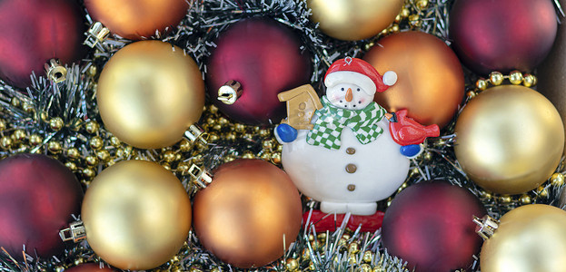 金色2022摄影照片_横幅与雪人与金色和红色的圣诞球。
