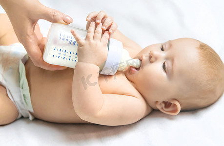 妈妈用奶瓶喂婴儿。