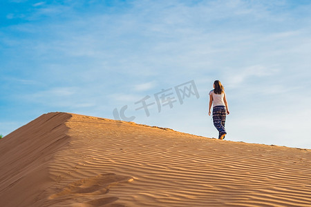 日落时在拉德沙漠中的年轻女子