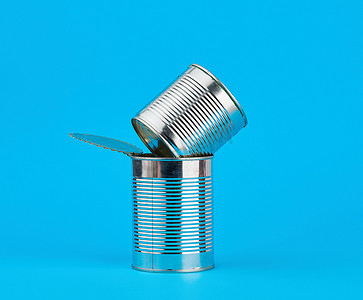 铁罐可口可乐摄影照片_蓝色背景下用于保存食品的打开硬铁罐