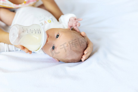 一送一摄影照片_一位姐姐正在给刚出生的婴儿喂奶。