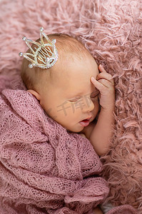 戴着女孩皇冠的新生婴儿。