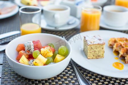 度假村餐厅早餐供应新鲜水果沙拉、华夫饼、蛋糕、咖啡和果汁