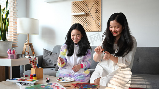 微笑的少女和她的小妹妹在家里一起度过闲暇时光时喜欢画画。