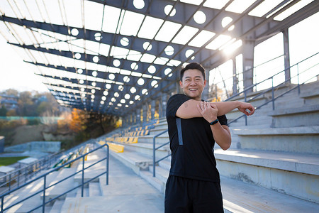 男运动员背着背包训练，亚洲健身在体育场外进行锻炼