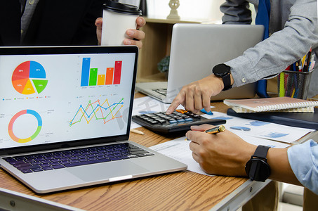 两会报告分析摄影照片_商务人士在办公室开会，通过分析财务图表和投资图表中的数据来规划营销团队。