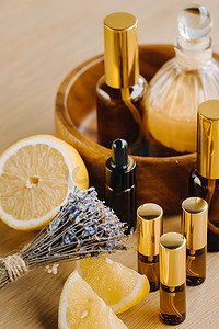 香水柠檬摄影照片_木质表面上装有柠檬和薰衣草香味的瓶子里的精油