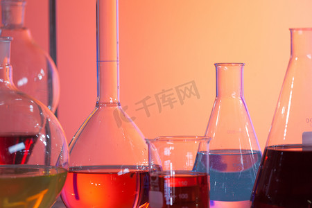 包含五颜六色的液体的由后面照的实验室测试烧瓶。