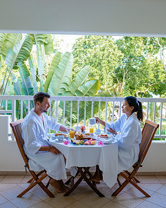 一对中年男女在毛里求斯豪华酒店公寓的阳台上吃早餐