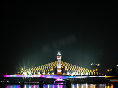 泰国城市夜景与黄昏时分河边摩天大楼和桥梁的美丽倒影。