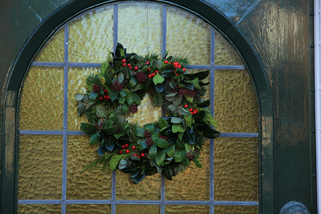 圣诞花环红色摄影照片_经典的圣诞花环，门上有装饰
