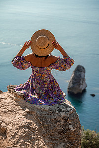 女孩望天空摄影照片_一位身穿彩色裙子、戴着帽子的女人的后视图，望向蓝色的海洋和天空，孤立的海洋背景