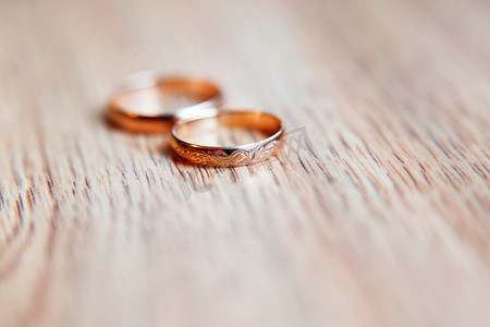 金色结婚戒指与木制背景上的装饰品。